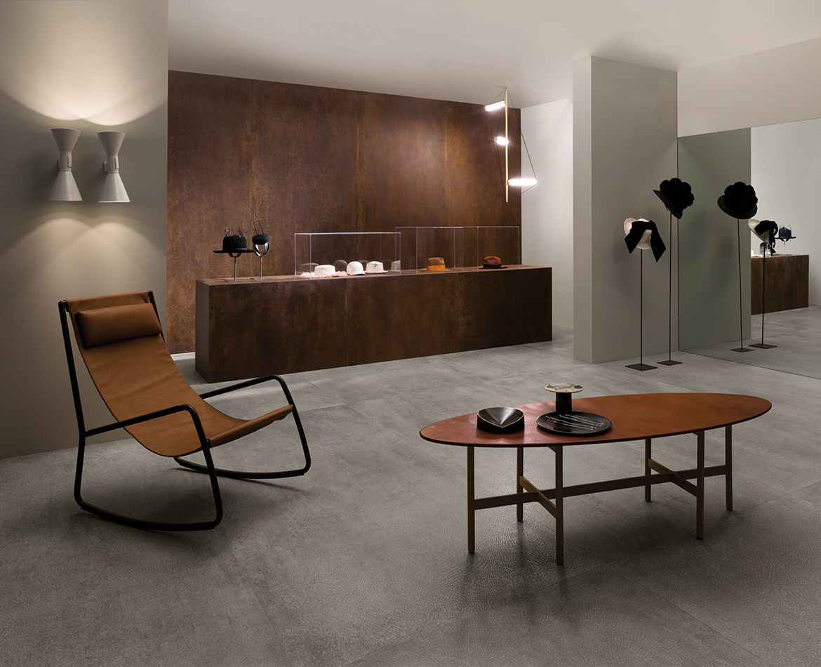 Moderner Showroom mit Cortenstahloptik-Wänden und grauem Feinsteinzeugboden