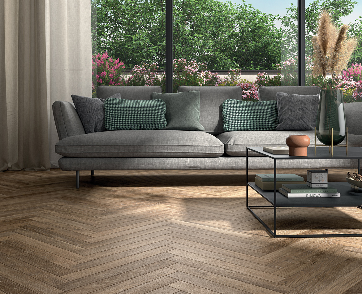Fischgrät-Verlegung aus Holzoptik-Feinsteinzeug im Wohnzimmer mit Gartenblick