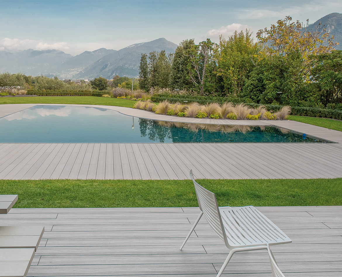 Poolbereich mit hellem WPC Holzoptik-Boden und Bergblick