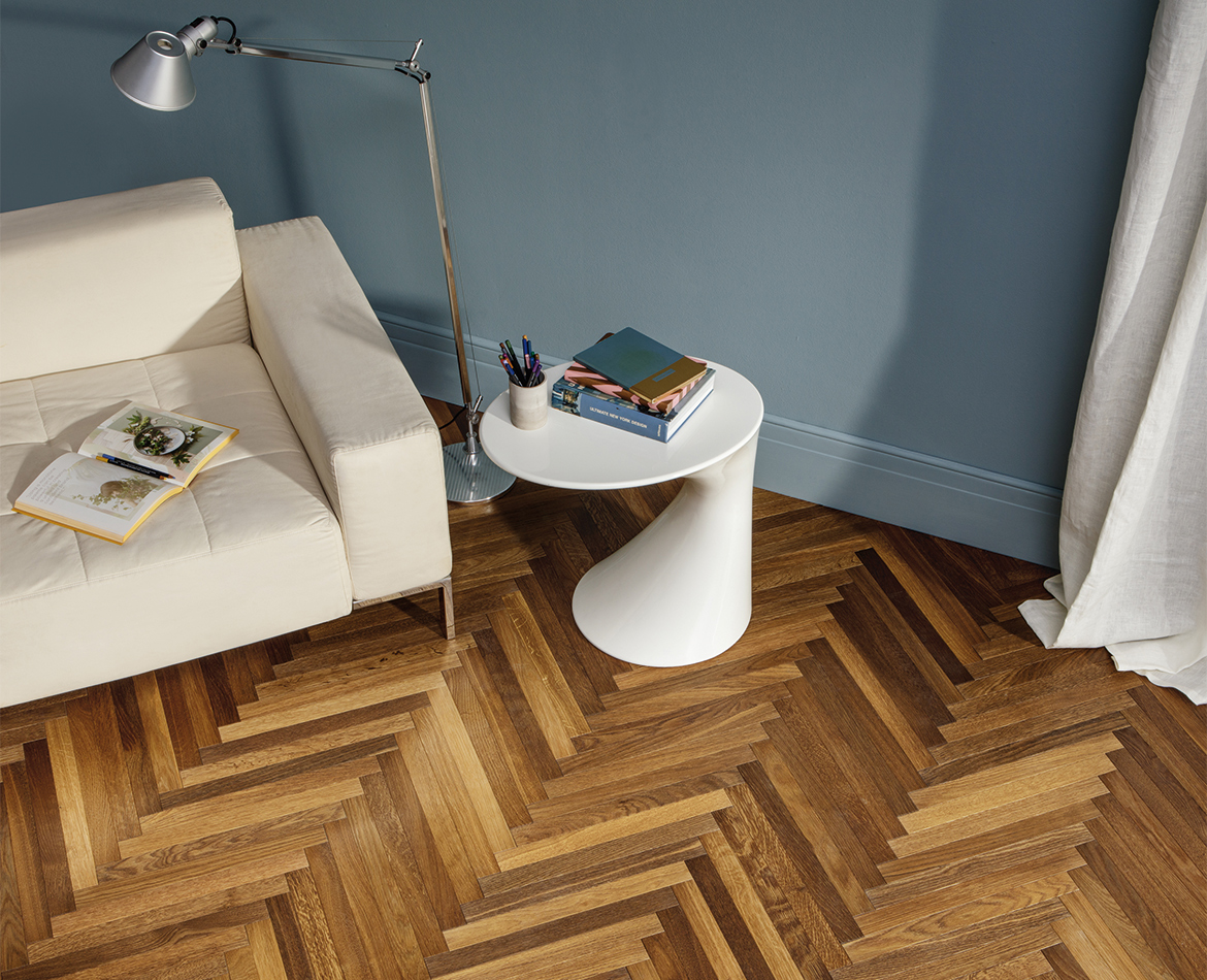 Helles Wohnzimmer mit Fischgrät-Holzboden und modernem Sofa