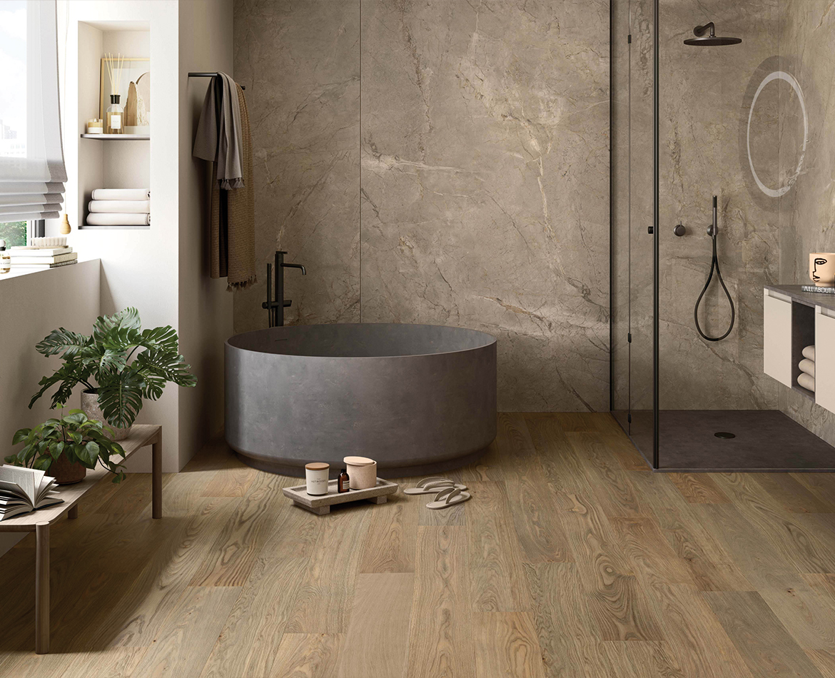 Badezimmer mit Holzfußboden und freistehender Betonbadewanne
