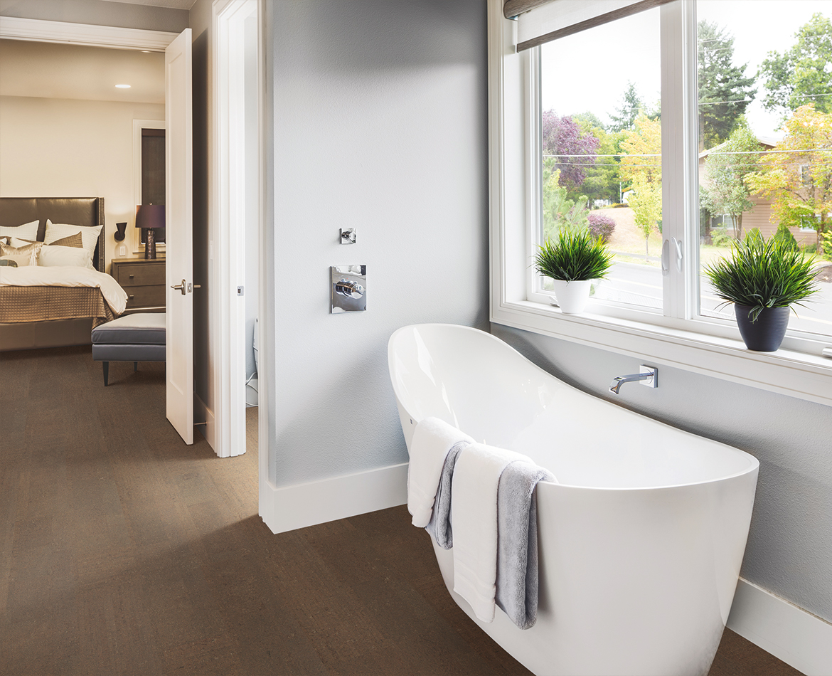 Badezimmer mit dunklem Korkboden und Blick ins Schlafzimmer