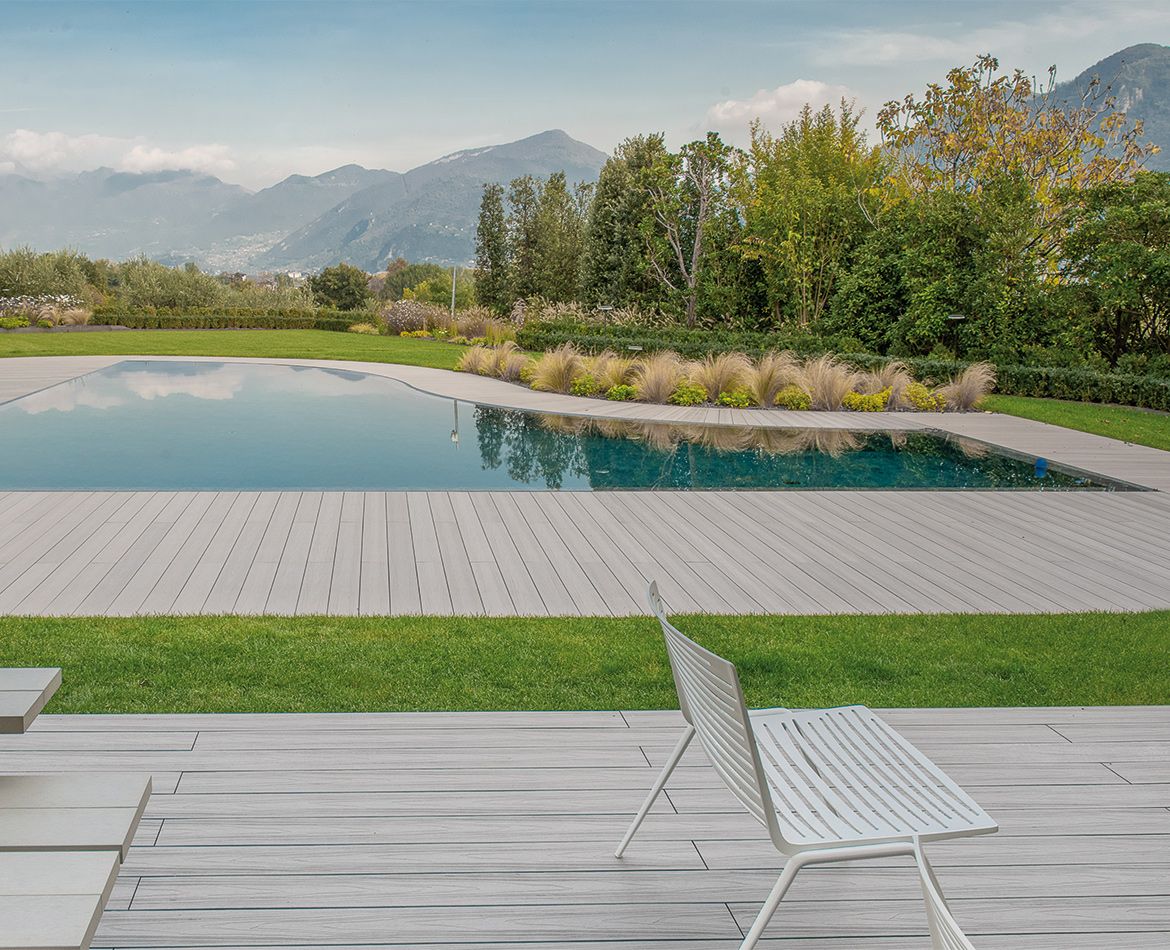 Poolbereich mit hellem WPC Holzoptik-Boden und Bergblick