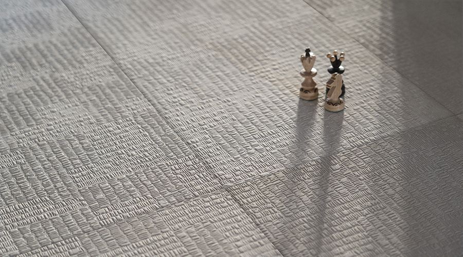    Strukturierte Feinsteinzeugfliese mit feiner Oberfläche und zwei Schachfiguren