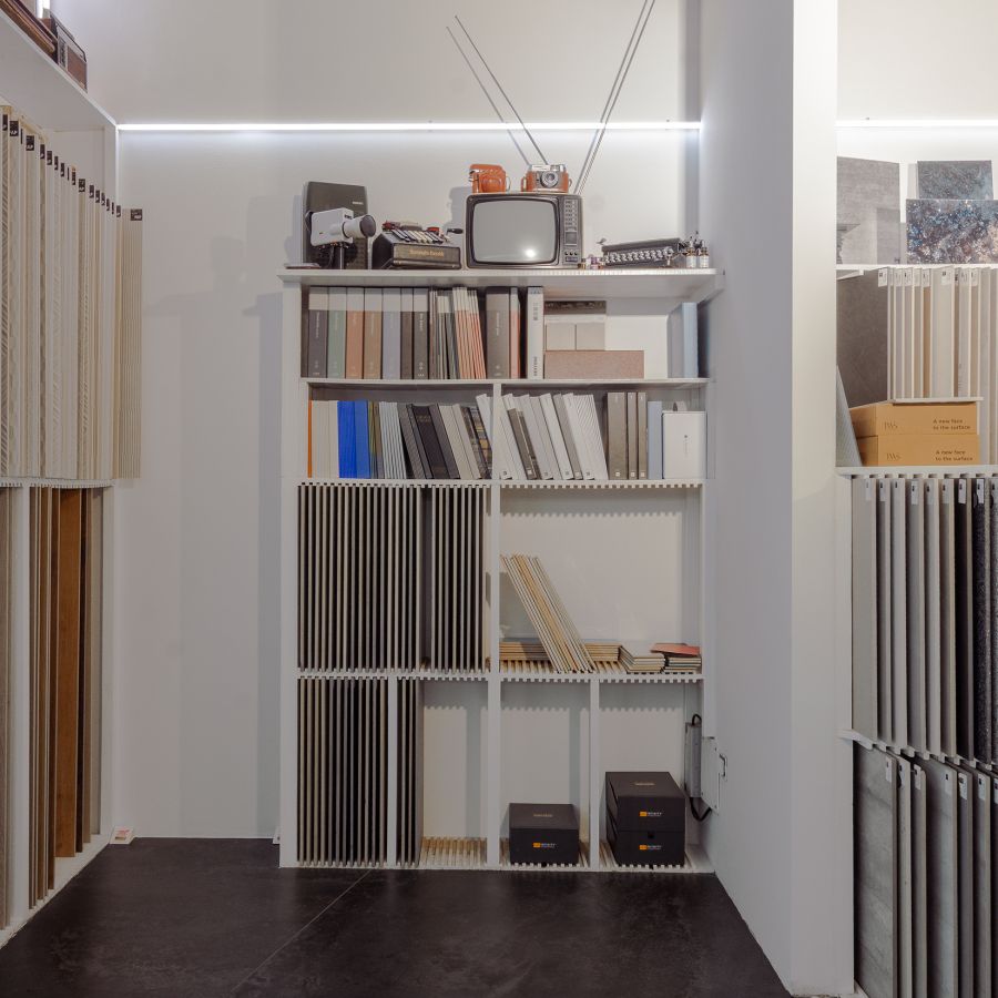 Materialbibliothek mit Musterplatten, Farbfächern und Vintage-Dekoration im Showroom